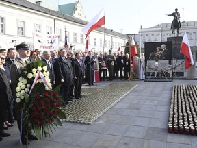 The leader of the ruling Law and Justice party Jaroslaw Kaczynski, left, attends a ceremony marking the eighth anniversary of the crash of the Polish government plane that killed Poland's President Lech Kaczynski and 95 others, outside the Presidential Palace in Warsaw, Poland, Thursday, April 10, 2018. (AP Photo)