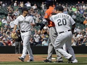 Seattle Mariners first baseman Daniel Vogelbach (20) tags out Houston Astros' Evan Gattis, second from right, for the third out of a triple play as Mariners' starting pitcher Marco Gonzales, left, looks on after Gattis left first base and started walking to the dugout after the first two outs during the fourth inning of a baseball game, Thursday, April 19, 2018, in Seattle.