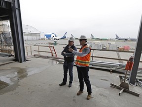 In this April 11, 2018 photo, Brett Smith, CEO of Propeller Airports, left, talks with project engineer Todd Raynes, right, inside the privately-run commercial U.S. airport terminal Smith's company is building at Paine Field in Everett, Wash. Propeller Airports sold $50 million in bonds earlier this year to finance the construction, according to data obtained by The Associated Press. The terminal has commitments from Alaska Airlines, Southwest Airlines and United Airlines for up to 24 daily flights, mostly to destinations in the West and Midwest.