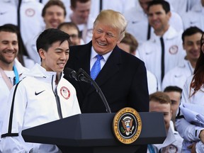 President Donald Trump listens to figure skater Vincent Zhou during a ceremony welcoming the Team USA Olympic athletes on North Portico at the White House in Washington, Friday, April 27, 2018. Zhou became the first figure skater to land a quadruple lutz in any Olympic Games when he completed the jump at the 2018 Winter Olympics.