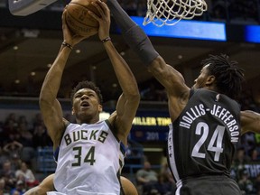 Milwaukee Bucks forward Giannis Antetokounmpo, left, is defended by Brooklyn Nets forward Rondae Hollis-Jefferson as he drives to the basket during the first half of an NBA basketball game Thursday, April 5, 2018, in Milwaukee.