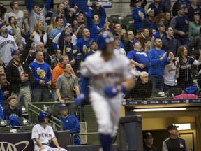 Fans cheer after Milwaukee Brewers' Travis Shaw, foreground, hit a solo home run against the Miami Marlins during the fourth inning of a baseball game Friday, April 20, 2018, in Milwaukee.