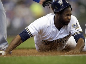 Milwaukee Brewers' Lorenzo Cain is picked off at first base by Chicago Cubs catcher Wilson Contreras during the first inning of a baseball game Sunday, April 8, 2018, in Milwaukee.