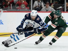 Zach Parise, right, of the Minnesota Wild looks to steal the puck from Blake Wheeler of the Winnipeg Jets during Game 3 action in their West Conference quarter-final Sunday in Minnesota. Parise had a goal as the Wild prevailed 6-2 to cut Winnipeg's lead in the series to 2-1.