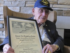 In this Wednesday, April 25, 2018 photo, World War II veteran Bob Barger poses with his Naval flight school certificate in Toledo, Ohio.