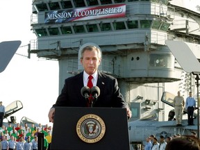 FILE - In this May 2, 2003 file photo, President George W. Bush declares the end of major combat in Iraq as he speaks aboard the aircraft carrier USS Abraham Lincoln off the California coast. As he declares the U.S.-led airstrikes against Syria a success, President Donald Trump is adopting a phrase that a previous president came to regret _ "mission accomplished." Back in 2003, a flight suit-clad President George W. Bush stood on an aircraft carrier under a giant "Mission Accomplished" banner and declared that "major combat operations in Iraq have ended" _ just six weeks after the invasion. But the war dragged on for many years after that.