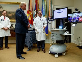 FILE - In this Aug. 3, 2017, file photo, Veterans Affairs Secretary David Shulkin, right, and White House physician Dr. Ronny Jackson, left, watch as President Donald Trump talks with a patient during a Veterans Affairs Department "telehealth" event in the Roosevelt Room of the White House in Washington. Trump's selection of his White House doctor to run the massive Department of Veterans Affairs has key lawmakers and veterans groups questioning whether he has the experience needed to manage the politically splintered agency.