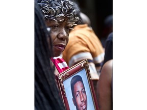 FILE - In this July 7, 2015 file photo, Gwen Carr holds a picture of her son, Eric Garner, during a news conference with relatives of New Yorkers killed by police, outside New York Gov. Andrew Coumo's office in New York. Federal civil rights prosecutors have recommended charging a New York police officer in the 2014 death of Eric Garner. But it's unclear if that will happen. That's according to a person familiar with the case who spoke to The Associated Press on condition of anonymity.