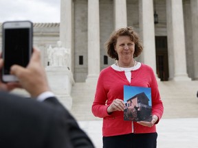Susette Kelo holds a photo of her little pink house as she is photographed in front of the Supreme Court building in Washington, Tuesday, April 17, 2018. The new movie "Little Pink House," directed by Courtney Balaker, is based on the story of the eminent domain Supreme Court case between Kelo and the City of New London, Conn.. Kelo lost her home when the Supreme Court ruled 5-4 in June 2005 that local governments may seize homes and businesses, even against the owners' will, for private economic development.