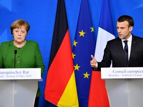 FILE - In this March 23, 2018, file photo, French President Emmanuel Macron, right, and German Chancellor Angela Merkel speak at a news conference in Brussels. The future of the landmark Iran nuclear deal hangs in the balance and its survival may depend on the unlikely success of last-minute European interventions with President Donald Trump. Macron and Merkel are to visit Washington separately later in April and will likely be the last foreign leaders invested in the deal to see Trump ahead of his mid-May deadline for the accord to be strengthened.