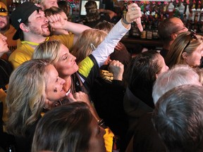 A person watching television coverage of the NFL football draft at a bar in Laramie, Wyo., gives a thumbs-down after Baker Mayfield was announced as the first pick, selected by the Cleveland Browns, in the draft Thursday, April 26, 2018.