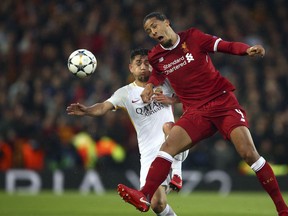 Roma's Cengiz Under fights for the ball with Liverpool's Virgil Van Dijk, right, during the Champions League semifinal, first leg, soccer match between Liverpool and AS Roma at Anfield Stadium, Liverpool, England, Tuesday, April 24, 2018.