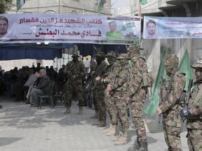 Masked militants from the Izzedine al-Qassam Brigades, a military wing of Hamas, stand while receive condolences outside of the house mourning of engineer Fadi al-Batsh, who was killed assassinated in Malaysia this morning, in front of his family house in Jebaliya, Gaza Strip, Saturday, April 21, 2018. Gaza's ruling Hamas militant group said Saturday that a man who was gunned down in Malaysia was an important member of the organization, raising suspicions that Israel was behind the brazen killing.