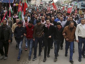 Mourners wave flags while the body of Palestinian journalist Ahmed Abu Hussein, who died after being shot by Israeli troops while covering a border protest, is carried during his funeral in the Jebaliya refugee camp, Gaza Strip, Thursday, April 26, 2018.