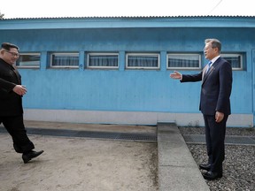 North Korean leader Kim Jong Un, left, walks to meet with South Korean President Moon Jae-in at the military demarcation line at the border village of Panmunjom in Demilitarized Zone Friday, April 27, 2018.