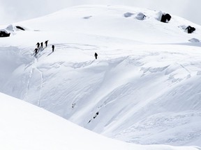 Rescue crews walk at an avalanche site near Fiesch, Switzerland, Sunday, April 1, 2018. Swiss police say three people have been killed in an avalanche in the Alps. Another two were taken to a hospital with light injuries. Police  say the avalanche hit the group of five skiers on Saturday afternoon. The group had set off from an Alpine hut earlier in the day to cross the Aletsch glacier in southern Switzerland.