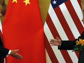 In this Nov. 9, 2017, photo, U.S. President Donald Trump, left, and Chinese President Xi Jinping prepare to shake their hands after a joint press conference at the Great Hall of the People in Beijing. The brewing China-U.S. trade conflict features two leaders who've expressed friendship but are equally determined to pursue their nation's interests and their own political agendas. But while Trump faces continuing churn in his administration and a tough challenge in midterm congressional elections, Xi leads an outwardly stable authoritarian regime. Xi recently succeeded in pushing through a constitutional reform allowing him to rule for as long as he wishes while facing no serious electoral challenge.