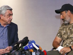 Former Armenian President Serzh Sargsyan, left, speaks with protest leader Nikol Pashinian during their meeting in Yerevan, Armenia, Sunday, April 22, 2018. Thousands of demonstrators on Saturday closed off streets in Yerevan during a march pressing demands for the prime minister to resign. Sargsyan was named premier this week as Armenia transitioned to a new system of government that reduces the presidency's power and bolsters the prime minister role.