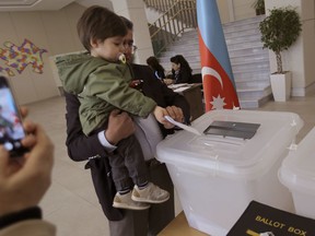 An Azeri man casts his ballot at a polling station during a presidential elections in Baku, Azerbaijan, Wednesday, April 11, 2018. Voters in the oil-rich Caspian Sea nation of Azerbaijan are set to cast ballots in a snap presidential election that is all but certain to extend the rule of the country's long-serving leader by another seven years.