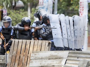 A Nicaraguan police officer aims his weapon at protesting students during a third day of violent clashes in Managua, Nicaragua, Friday, April 20, 2018. The clashes, pitting protesters opposed to social security reforms against riot police and pro-government groups, have rocked the capital, and a half-dozen other cities over the last three days. The Organization of American States have expressed concern over the heavy-handed crackdown, while also calling on demonstrators to protest peacefully.