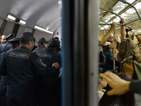 Opposition demonstrators block the entrance of an underground carriage during a protest against the former president's shift into the prime minister's seat, in Yerevan, Armenia, Monday, April 16, 2018. Thousands of opposition supporters have blocked traffic in the Armenian capital over a recent change of government that the opposition sees as a move for the ex-president to stay in power.