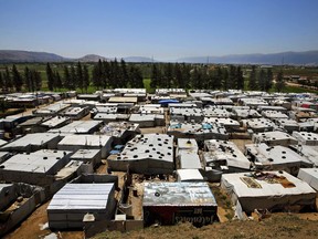 This Monday, April 23, 2018 photo, Syrian refugees walk outside their tents at a Syrian refugee camp in the town of Bar Elias, in Lebanon's Bekaa Valley. A leading international rights group and the U.N.'s refugee agency say Lebanese authorities have been evicting Syrian refugees from towns and camps in Lebanon without any legal basis.