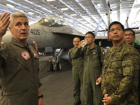 Rear Admiral Steve Koehler, left, commander CSG-9 of the U.S. aircraft carrier Theodore Roosevelt, briefs top Philippine generals led by Lt.Gen. Rolando Joselito Bautista, foreground right, Tuesday, April 10,2018, in international waters off South China Sea. The aircraft carrier CVN-71 is sailing through the disputed South China Sea in the latest display of America's military might after China built a string of islands with military facilities in the strategic sea it claims almost in its entirety.