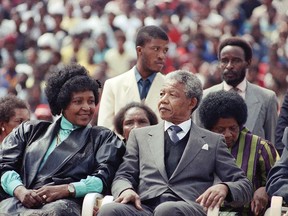 FILE - In this Feb. 13, 1990 file photo, Winnie Mandela, left, with her former husband Nelson Mandela, right, at a rally in Soweto, South Africa shortly after his release from 27 years in prison. South African state broadcaster SABC says anti-apartheid activist Winnie Madikizela-Mandela has died aged 81, it was reported on Monday, April 2, 2018. (AP Photo, File)