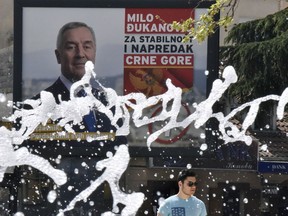 In this photo taken on Thursday, April 12, 2018, a man walks past a billboard showing Montenegro's long-time leader Milo Djukanovic, reading: ''Milo Djukanovic, for stability and progress of Montenegro'' in Montenegro's capital Podgorica. Djukanovic is seeking a new term as president at the election this weekend after defying Russia to lead the small Balkan country into NATO last year.