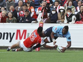 Taqele Naiyaravoro of Australia's Waratahs, right, scores a try as Timothy Lafaele of Japan's Sunwolves defends during their Super Rugby match at Chichibunomiya Rugby Stadium Saturday, April 7, 2018, in Tokyo.