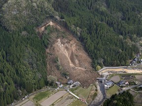 A landslide site is seen Wednesday April 11, 2018 in Nakatsu, Oita Prefecture, in southern Japan. Japan's Fire and Disaster Management Agency says the landslide occurred around 3:50 a.m. Wednesday in Oita prefecture on Kyushu, the southernmost of Japan's four main islands. The agency said it left six missing and damaged four homes.