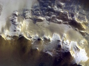 In this image provided by the European Space Agency, ESA, The ExoMars Colour and Stereo Surface Imaging System, CaSSIS, captured this view of the rim of Korolev crater (73.3ºN/165.9ºE) on 15 April 2018. The European Space Agency has released its first image taken by a probe orbiting Mars, showing the ice-covered edge of a vast crater. Scientists combined three pictures taken by the Trace Gas Orbiter's camera instrument, CaSSIS, from an altitude of 400 kilometers (249 miles) on April 15. (ESA/Roscosmos/CaSSIS via AP)
