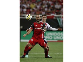 Toronto FC's Victor Vazquez, front, fights for the ball with Chivas' Isaac Brizuela during the CONCACAF Champions League final soccer match in Guadalajara, Mexico, Wednesday, April, 25, 2018.