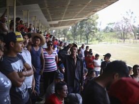 Central American migrants gather at a sports center during the annual Migrant Stations of the Cross caravan or "Via crucis," organized by the "Pueblo Sin Fronteras" activist group, in Matias Romero, Oaxaca state, Mexico, Monday, April 2, 2018. The group of about 1,100 people, most of them Hondurans, had been walking along roadsides and train tracks, but have stopped to camp out in this field and wait to get advice on filing for transit or humanitarian visas in Mexico.
