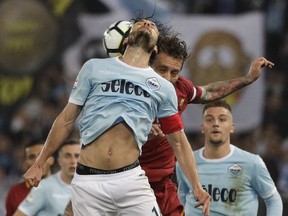 Lazio's Marco Parolo, front, and Roma's Daniele De Rossi vie for the ball during an Italian Serie A soccer match between AS Roma and Lazio, at the Olympic stadium in Rome, Sunday, April 15, 2018.