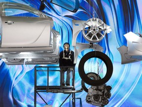 FILE - In this April 18, 2015, file photo,  a worker prepares a display ahead of the Auto Shanghai show, to be held at the National Exhibition and Convention Center in Shanghai.  Chinese exporters of goods from electronics to motorcycle parts are scrambling to insulate themselves from U.S. President Donald Trump's proposed tariff hike. They are weighing plans to rush shipments to American customers ahead of the increase, raise prices or find other markets. Some are looking at shipping goods through other countries to hide their Chinese origin.