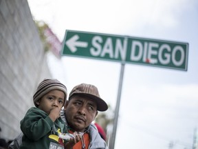A father and his son await tutorship by immigration lawyers in Tijuana, Mexico, Friday, April 27, 2018. Close to to 200 migrants from Central America, mostly from Honduras, arrived in Tijuana seeking to enter the United States.