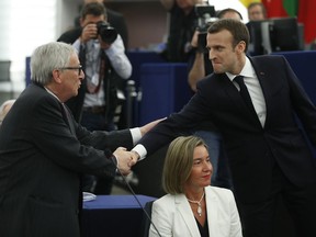 French President Emmanuel Macron, right, shakes hands with European Commission President Jean-Claude Juncker at the European Parliament in Strasbourg, eastern France, Tuesday, April 17, 2018. Macron is expected to outline his vision for the future of Europe to push for deep reforms of the 19-nation eurozone and will launch a drive to seek European citizens' opinions on the European Union's future.