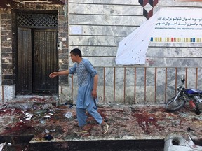 An Afghan man walks outside a voter registration center,  which was attacked by a suicide bomber in Kabul, Sunday, April 22, 2018.