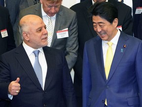 Iraq's Prime Minister Haider al-Abadi, left, talks with Japanese Prime Minister Shinzo Abe at the opening ceremony of the expert level of the international conference on Iraqi economic development in Tokyo, Thursday, April 5, 2018.