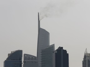 Smoke rises from the tip of the Almas Tower in Dubai's Jumeirah Lake Towers neighborhood, Sunday, April 22, 2018.