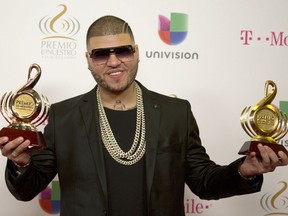 In this Feb. 19, 2015 file photo, Farruko poses for photos with the trophies he won at the Premio Lo Nuestro awards show in Miami. Federal agents have arrested the Puerto Rican singer, whose name is Carlos Efren Reyes shortly after he arrived in the U.S. territory from a trip to the Dominican Republic on Tuesday, April 3, 2018. A spokesman for U.S. Customs and Immigration Enforcement tells The Associated Press on that Farruko will appear in court soon on charges that have not yet been made public.