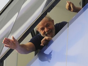 FILE - In this April 7, 2018 file photo, Brazil's former President Luiz Inacio Lula da Silva waves to supporters from a window of the Metal Workers Union headquarters in Sao Bernardo do Campo, Brazil, before he was later jailed for corruption on the same day. Imprisonment has not knocked the former president out of the lead in Brazil's upcoming presidential race. He also leads in all proposed runoff combinations.