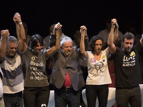 Brazil's former President Luiz Inacio Lula da Silva, center, stands with, from left, Brazilian singer Chico Buarque, Manuela D'Avila of the Communist Party of Brazil, Brazil's former President Luiz Inacio Lula da Silva, Monica Benicio, widow of slain councilwoman Marielle Franco and Rio's state Congressman Marcelo Freixo during da Silva's presidential campaign rally with members of his Workers Party and leaders of other left-wing parties in Rio de Janeiro, Brazil, Monday, April 2, 2018. Despite a conviction on corruption charges that could see him barred from running, da Silva is the front runner in that race.
