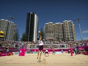 FILE - In this April 6, 2018 file photo, Seain Cook of Scotland serves the ball while playing in a preliminary round mens beach volleyball match with teammate Robin Miedzybrodzki against Sri Lanka at the Coolangatta Beachfront during the 2018 Commonwealth Games on the Gold Coast, Australia.The men's and women's beach volleyball finals are scheduled for Thursday at the Commonwealth Games. The sport has been a perfect fit for the sun and surf culture on the Gold Coast and has attracted sold-out crowds to a temporary stadium on the beach at Coolangatta.