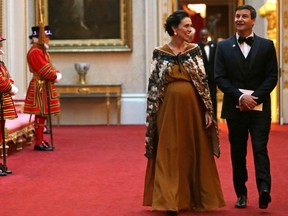 FILE - In this April 19, 2018 file photo, New Zealand's Prime Minister Jacinda Ardern and her partner Clarke Gayford arrive in the East Gallery at Buckingham Palace in London as Queen Elizabeth II hosts a dinner during the Commonwealth Heads of Government Meeting (CHOGM). As citizens of a small and isolated nation, New Zealanders often seek validation from abroad. By that measure, Prime Minister Jacinda Ardern returned triumphant this week from a trip to Europe.