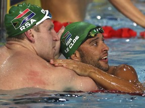 South Africa's Chad Le Clos, talks with compatriot Ryan Coetzee, left, after their men's 50m butterfly semifinal at the Aquatic Centre during the 2018 Commonwealth Games on the Gold Coast, Australia, Thursday, April 5, 2018.