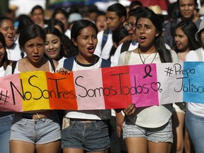 Students hold a sign that reads in Spanish "It's not three, it's all of us" during a protest against the murder of three film students who have become emblematic of Mexico's missing, in Guadalajara, Mexico, Thursday, April 26, 2018. Prosecutors said the three were abducted by the Jalisco New Generation Cartel because they were filming a school project at a house used by the rival Nueva Plaza gang. The students were using the residence because it belonged to one of their aunts.