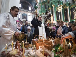 A Lithuanian Orthodox priest blesses cakes and Easter eggs during an Orthodox Easter ceremony at the Orthodox Church of the Holy Spirit in Vilnius, Lithuania, Saturday, April 7, 2018. Orthodox Christians around the world celebrate Easter on Sunday, April 8.