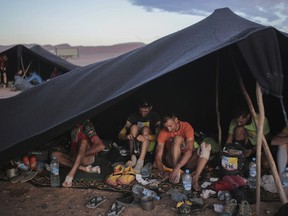 Competitors prepare in a bivouac before sunrise as they get ready to take part in the 33rd edition of Marathon des Sables, in the Sahara desert, near Merzouga, southern Morocco, Friday, April 13, 2018. Under a hot desert sun and with the desolation of the Sahara all around, about 1,000 competitors from 50 countries took part in this year's Marathon des Sables, or Marathon of the Sands. The 33rd edition of the annual race, considered to be one of the most demanding ultramarathons in the world, finished Saturday after six grueling days and about 250 kilometers (150 miles).